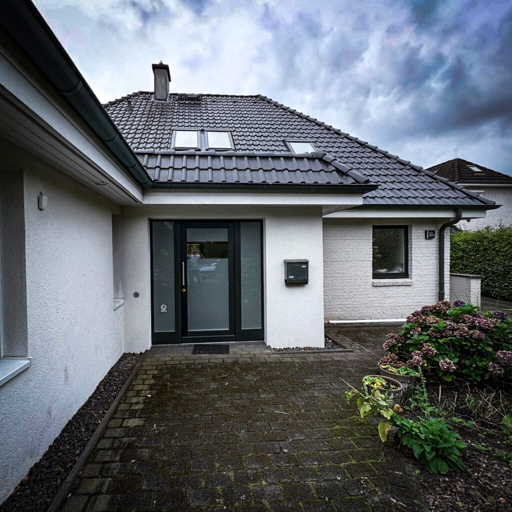 Weiße Fassade eines Einfamilienhauses mit Garage