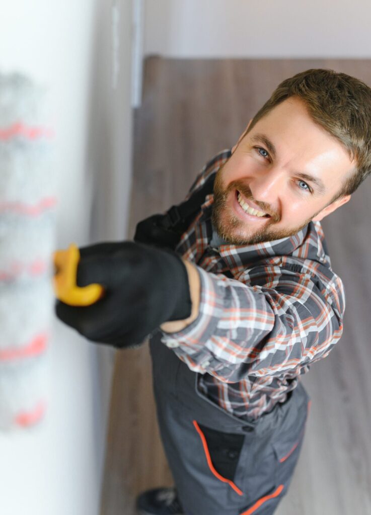 Maler streicht eine Wand mit der Farbrolle